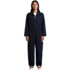 Woman in a navy blue coverall and brown shoes standing against a white background.