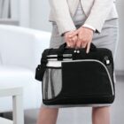 Person in business attire holding a black briefcase with pens in the front mesh pocket.
