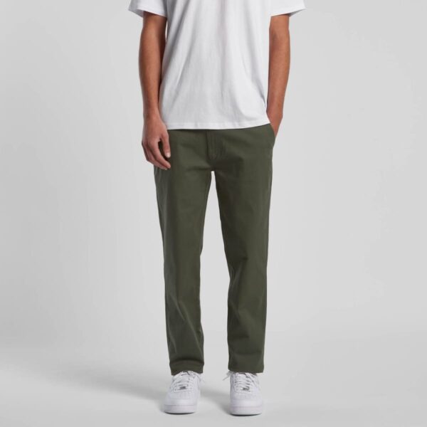 Person wearing a white t-shirt, olive green pants, and white sneakers, standing upright.