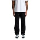 Person in white t-shirt, black pants, and sneakers standing against a white background.