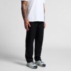 Person wearing a white t-shirt, black pants, and gray sneakers, with tattooed arms visible.