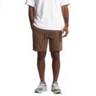 Man wearing a white t-shirt, brown shorts, and gray sneakers, standing against a white background.