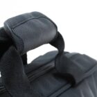 Close-up of a black fabric bag handle against a white background.