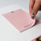 A hand peels a note from the Promotional A3 Magnetic Whiteboard w/ Notepads.