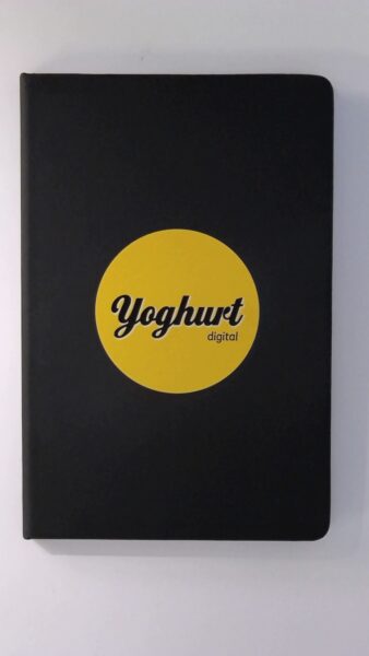Black notebook for business with a yellow circle labeled Yoghurt digital on the cover.