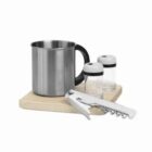 Metal mug, salt and pepper shakers, corkscrew, and wooden board on white background.