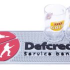 Two XXXX Gold beer mugs on a Defcredit service banking mat with military icons.