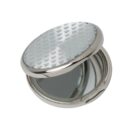 A round, silver compact mirror with a patterned lid, slightly open to reveal the mirror.