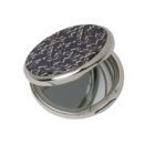 A round compact mirror with a decorative, textured lid, partially open.