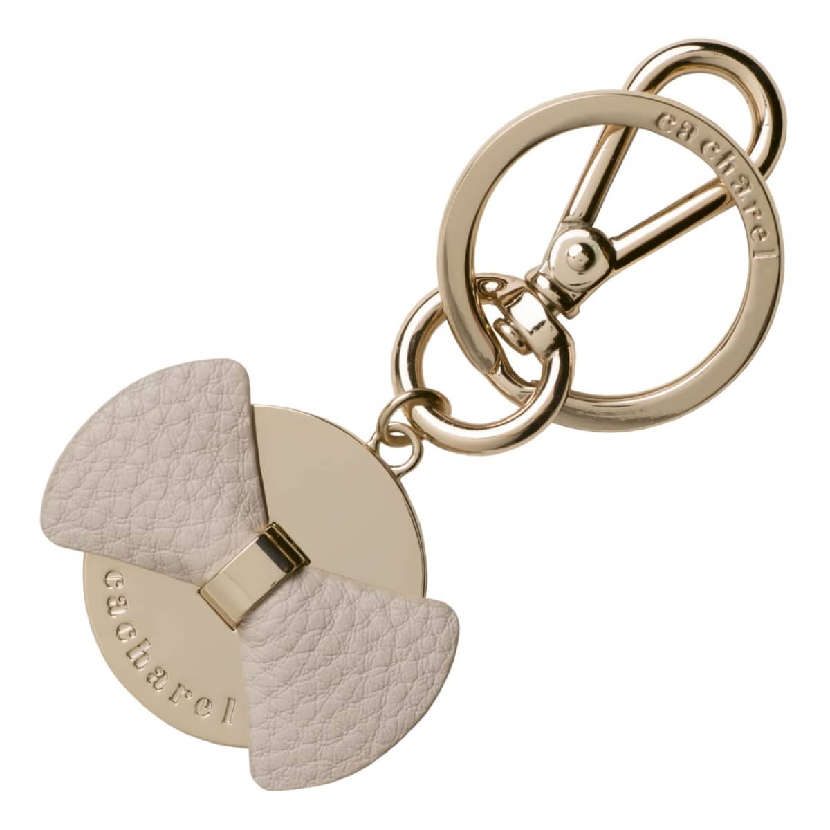 Gold keychain with a round base and a textured beige bow, engraved with cacharel.