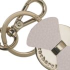 Gold keychain with round charm and light beige leather accent, close-up view.
