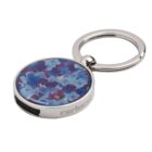 Round keychain with a floral blue and purple design and silver metal edges.