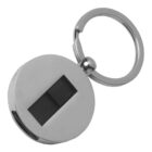 Round silver keychain with a small black rectangular button in the center.
