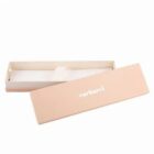 Light pink rectangular Cacharel gift box with lid removed and placed beside the box.