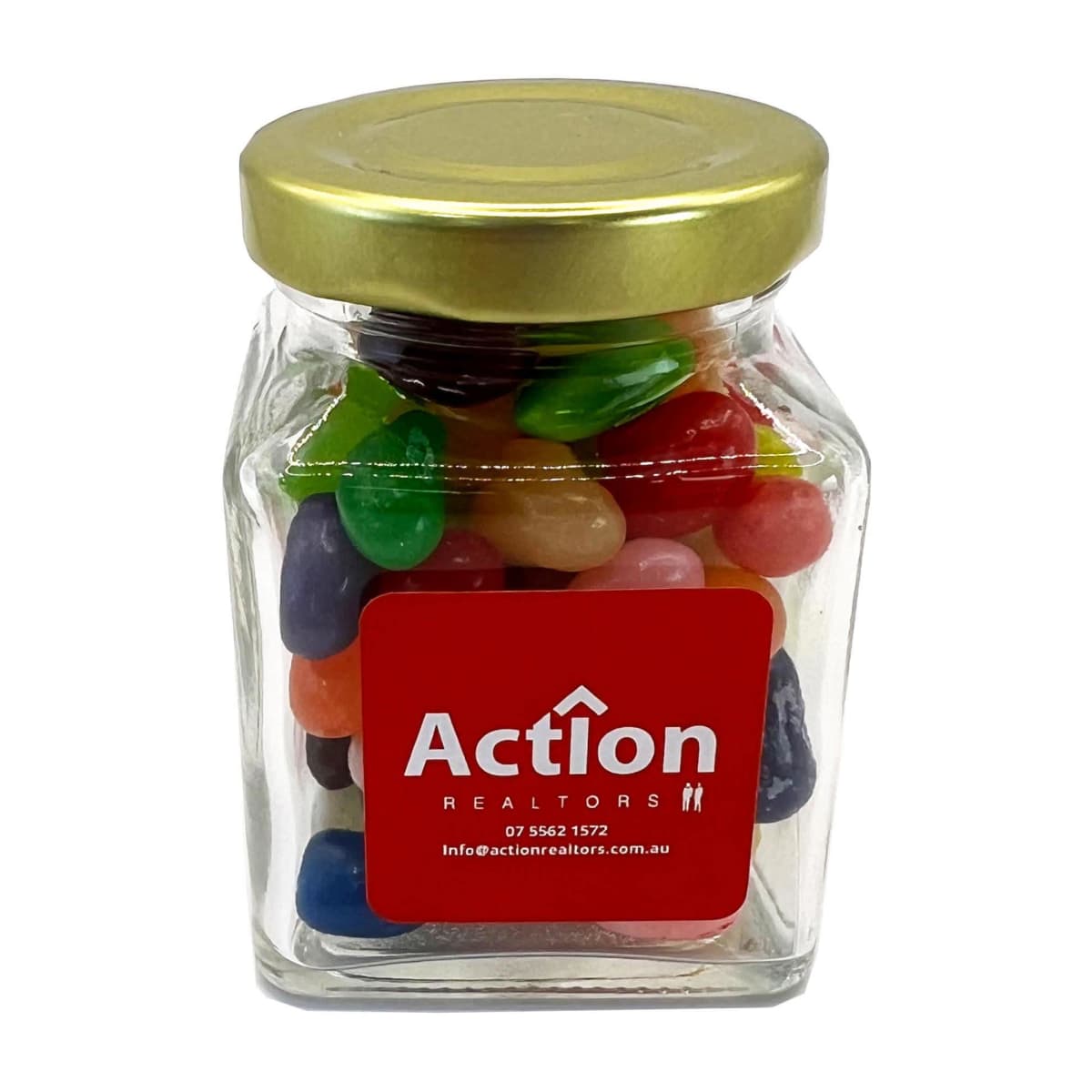 Square glass jar of colorful jelly beans with a gold lid and red Action Realtors label.