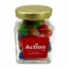 A glass jar with a gold lid, filled with colorful candy, labeled “Action.”.
