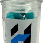A glass jar with a lid, filled with blue candies and a geometric H logo on the front.