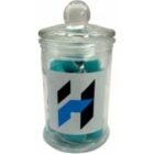 A glass jar with a lid, filled with blue items and labeled with a bold H logo.