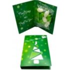Green holiday card with a geometric Christmas tree and a packet of candies inside.
