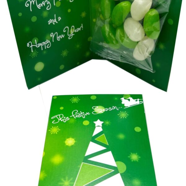 Green holiday card with tree design, message, and packet of green and white candies inside.