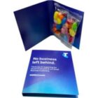 Open blue Telstra card with colorful candy in a clear pouch attached inside.