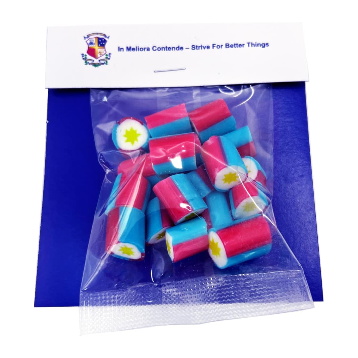 Colorful cylindrical candy pieces in a clear bag, on blue card with a crest and motto above.