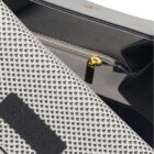 Close-up of a white perforated handbag with a gold zipper and black Coachard Paris label.
