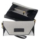 Black and white clutch purse with gold accents, shown open and closed.