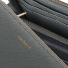 Close-up of a gray Cacharel wallet with visible gold logo and zippered compartments.