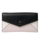 A color-blocked wallet with black, white, and light pink leather panels and a snap closure.