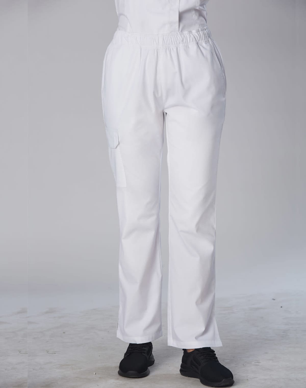Person wearing white pants and black shoes, standing on a light-colored floor.