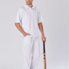 Man in white sportswear holding a cricket bat, standing against a plain background.