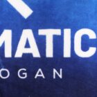 White partial text on a blue background, with visible letters “MATIC” and “OGAN” in bold font.