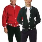 Two people wearing varsity jackets, one red and one black, both smiling at the camera.