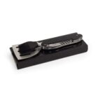 A multi-tool BBQ utensil set with a spatula and basting brush on a black box.