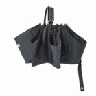A black, semi-open compact umbrella against a white background.