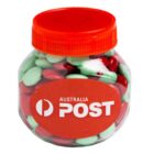 A jar with red lid, filled with red and green candies, labeled “Australia Post.”.