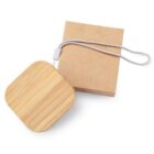 Square bamboo keychain with a white cord, placed next to a brown paper box.