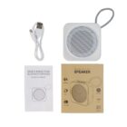 Square wireless speaker with charging cable, instruction manual, and product box displayed.