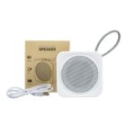 White wireless speaker with a lanyard, USB cable, and brown packaging box.