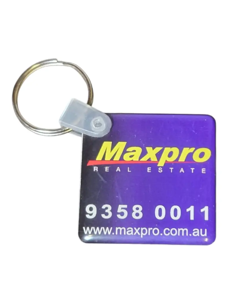 Purple Maxpro Real Estate keychain with phone number and website, on white background.