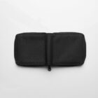 A black zippered fabric pouch lies open on a white background.