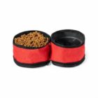 Two red collapsible pet bowls, one filled with kibble and one empty, side by side.