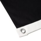 Close-up of a black fabric corner with a white edge and metal grommet.