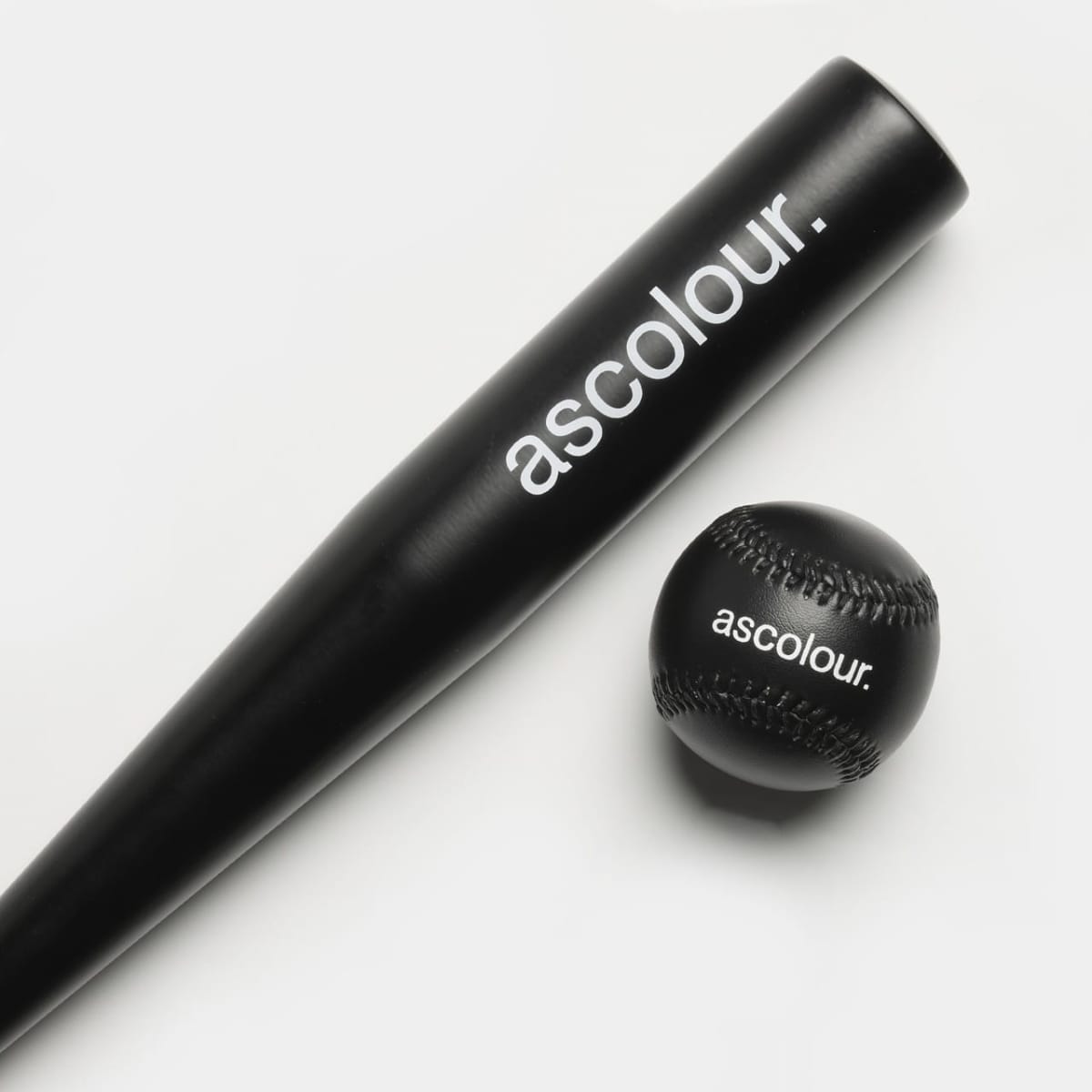 Black baseball bat and ball with ascolour. branding on a white background.