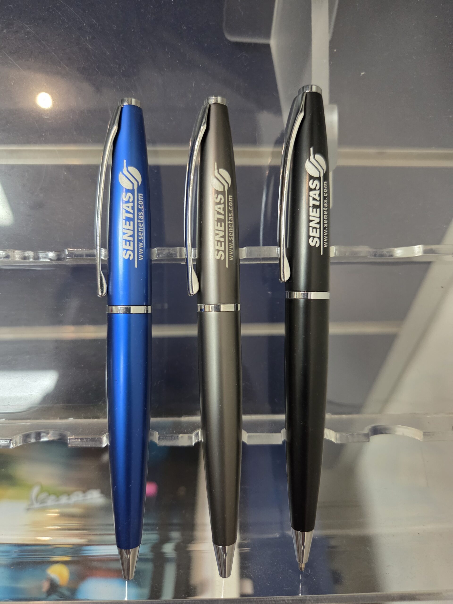 3 ball pens in color blue, gray and black on a glass surface