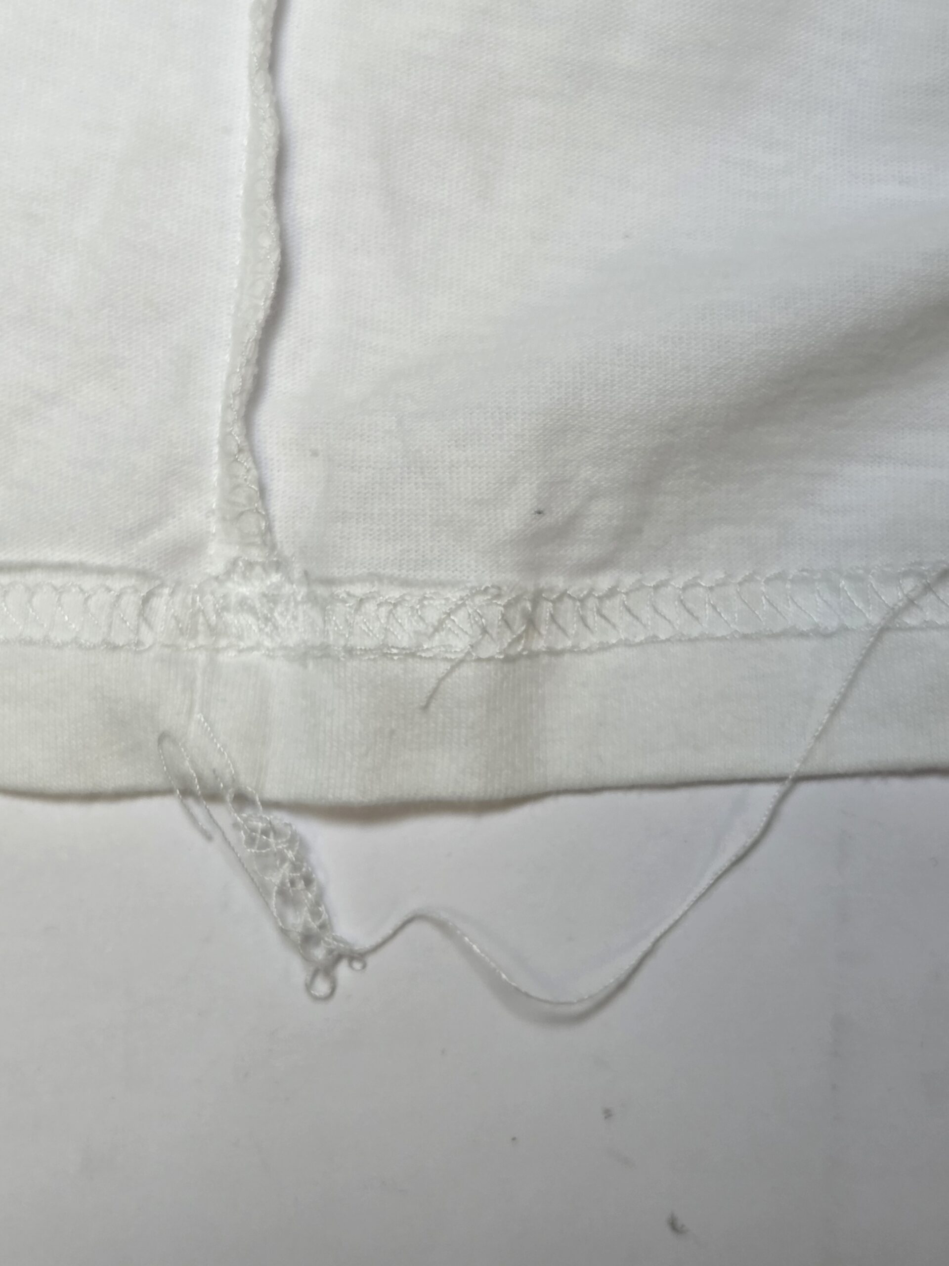Inside view of a shirt sleeve showing excess thread