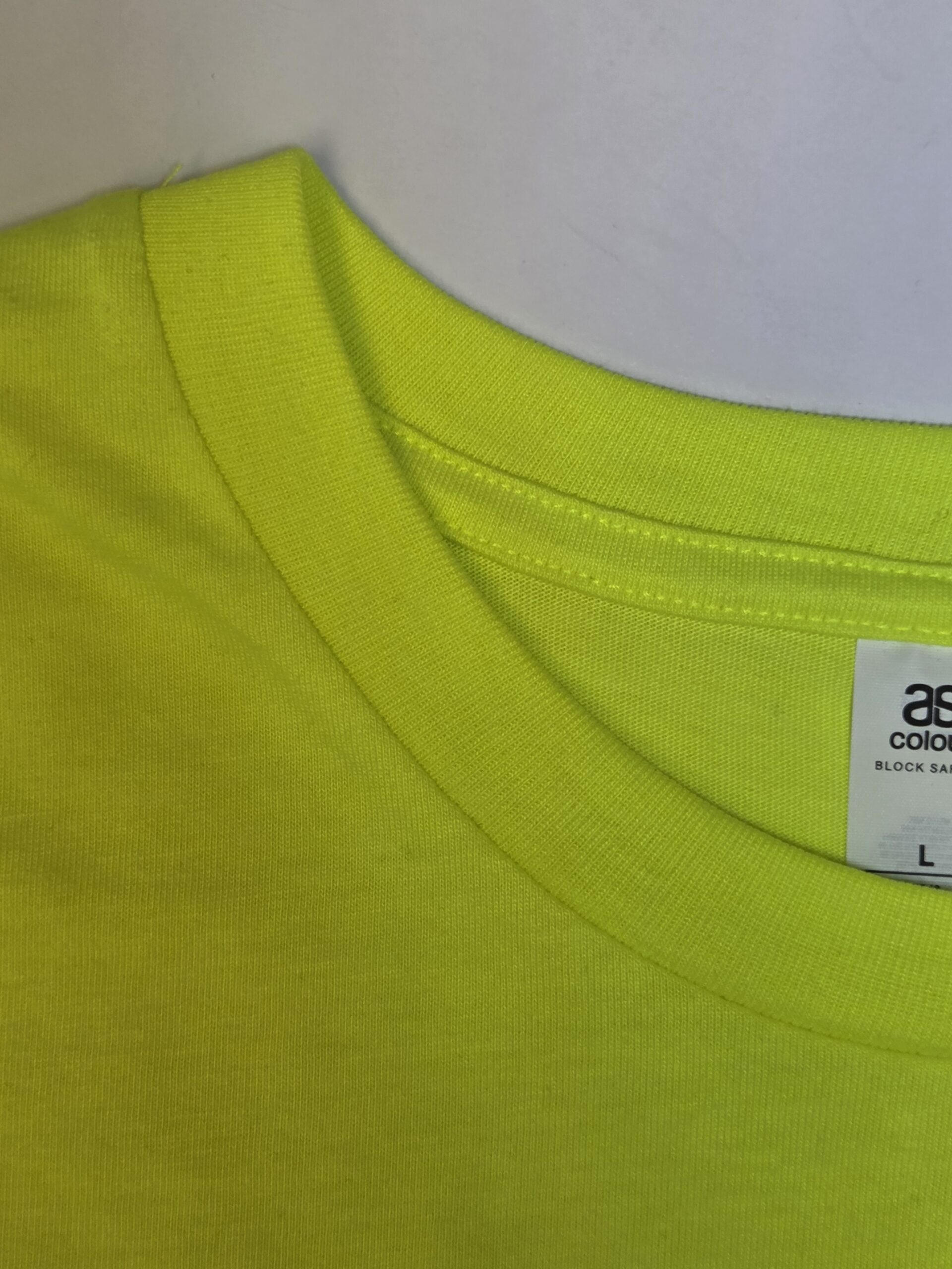 Detailed shot of neon green shirt neckline highlighting stitching and fabric quality