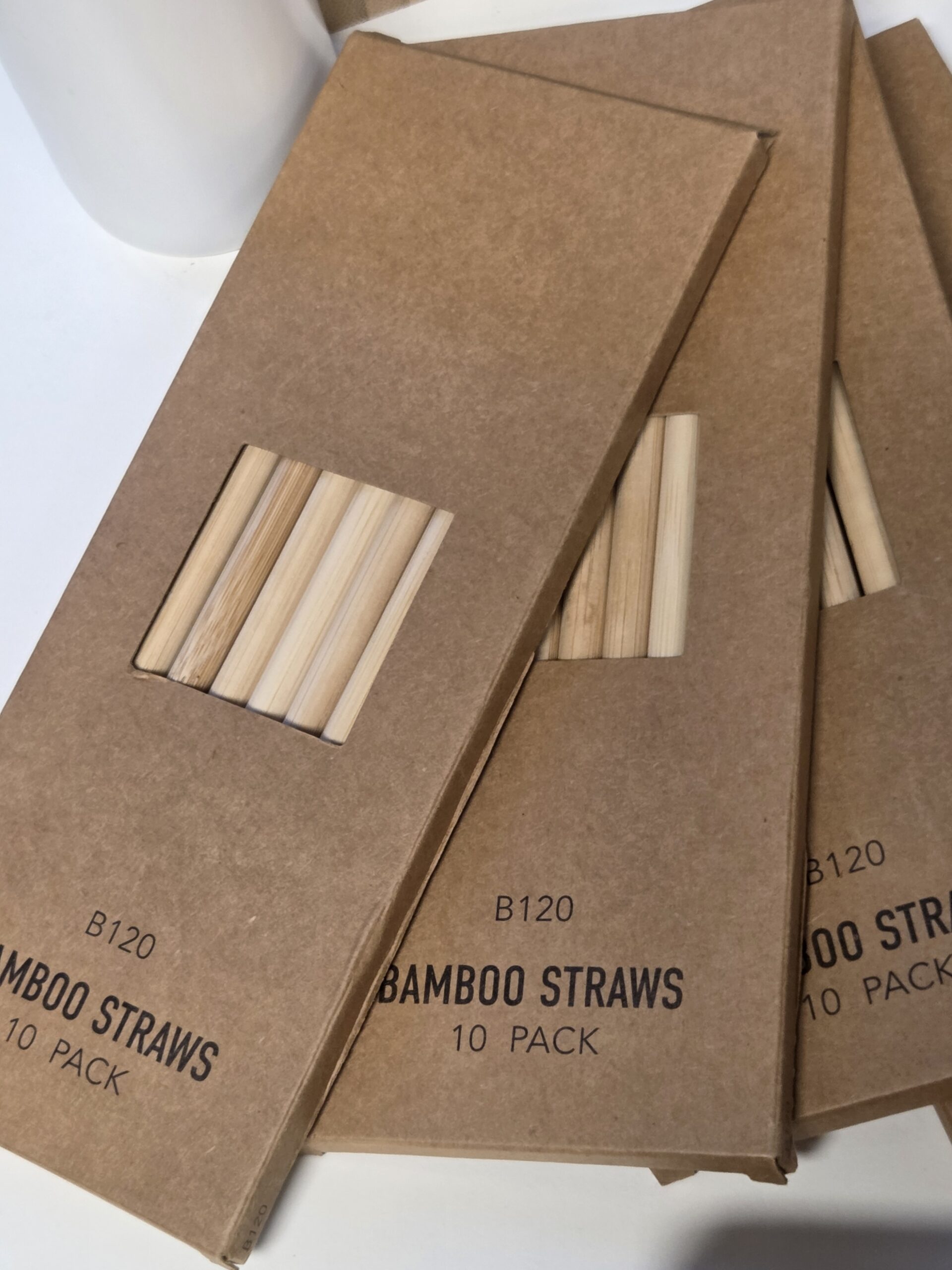 Three cardboard packs of bamboo straws, each labeled bamboo 10 pack, are stacked on a surface.