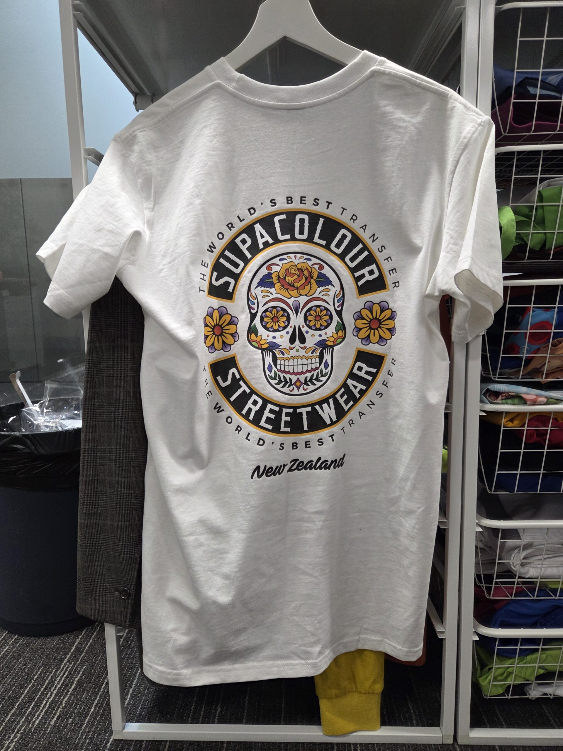 White t-shirt with a colorful sugar skull, featuring digital full colour transfer printing and branding.